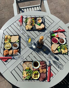 Four rectangular platters on a grey slatted wooden table.